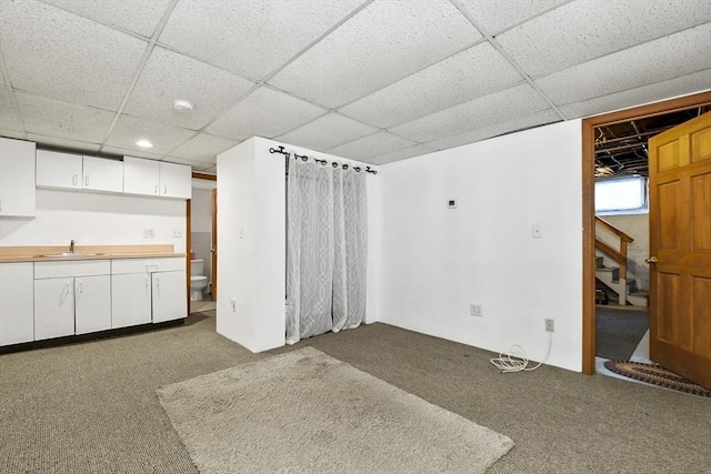 9 Aspinwall Ave, Weymouth, MA 02191 - unfurnished living room with carpet flooring, a sink, a paneled ceiling, stairs, and recessed lighting