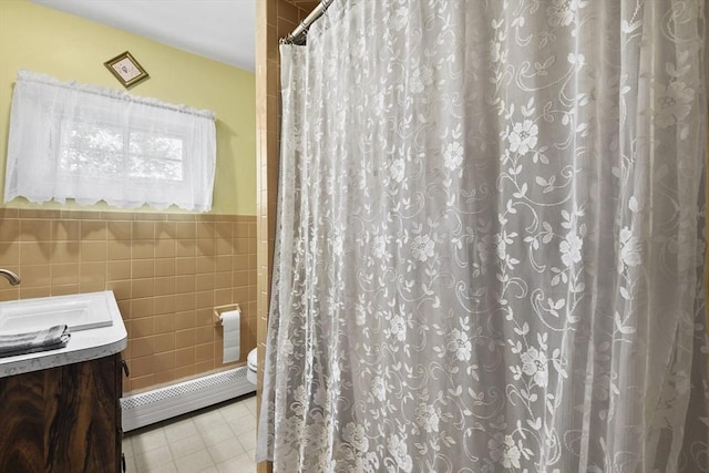 9 Aspinwall Ave, Weymouth, MA 02191 - bathroom featuring a baseboard heating unit, tile walls, vanity, toilet, and wainscoting