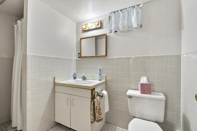9 Aspinwall Ave, Weymouth, MA 02191 - bathroom featuring tile walls, a wainscoted wall, toilet, vanity, and tile patterned flooring