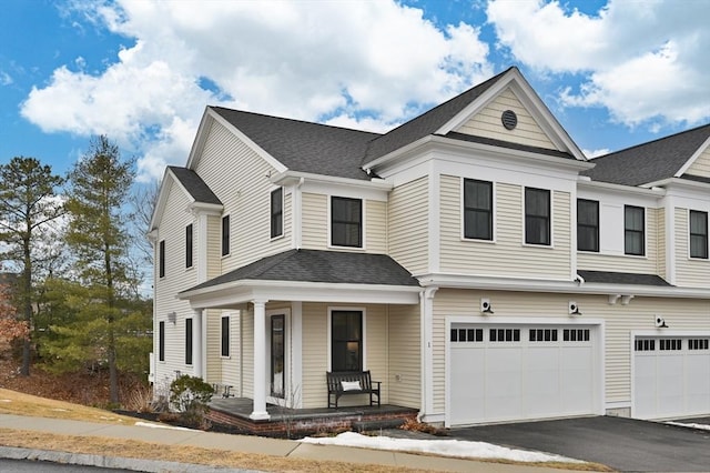 multi unit property featuring a garage, covered porch, driveway, and a shingled roof