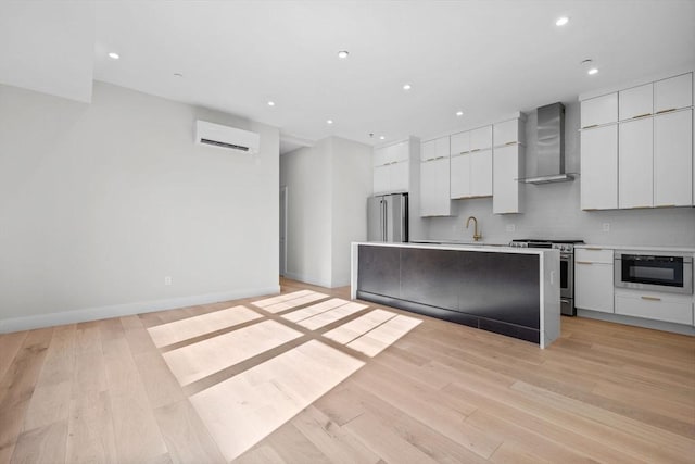 1 Marion St Unit 2, Cambridge, MA 02141 - kitchen featuring stainless steel appliances, wall chimney range hood, modern cabinets, an AC wall unit, and white cabinetry