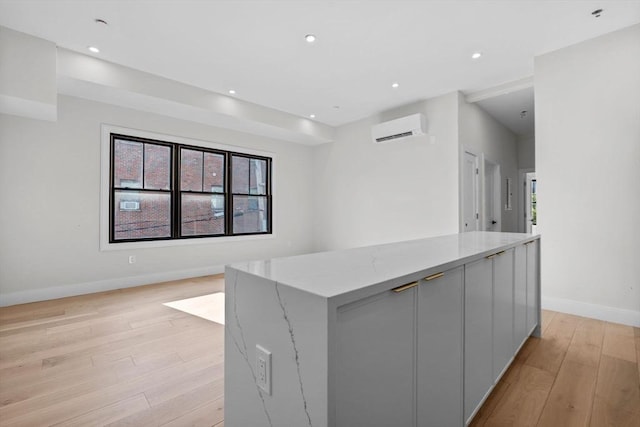 1 Marion St Unit 2, Cambridge, MA 02141 - kitchen featuring a wall mounted AC, baseboards, light wood-type flooring, a kitchen island, and modern cabinets