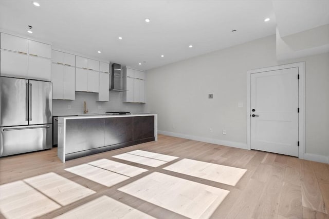 1 Marion St Unit 2, Cambridge, MA 02141 - kitchen featuring high quality fridge, wall chimney exhaust hood, light wood-style floors, white cabinetry, and recessed lighting
