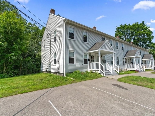 135 Border St Unit 135, Northbridge, MA 01588 - townhome / multi-family property featuring a chimney, covered porch, uncovered parking, and a front yard