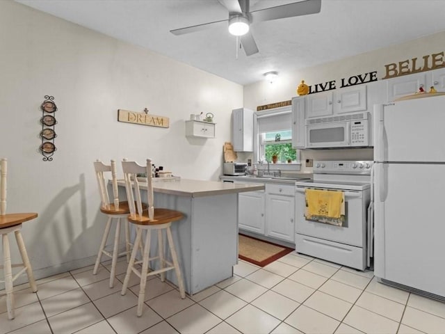 135 Border St Unit 135, Northbridge, MA 01588 - kitchen with white appliances, a peninsula, a breakfast bar, white cabinets, and ceiling fan