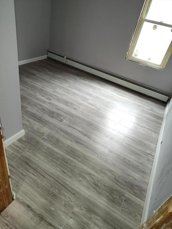 54 Marietta St, North Adams, MA 01247 - unfurnished room with a baseboard heating unit, baseboards, and wood finished floors