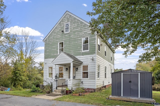 front of property with a storage shed and a front yard