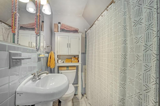 bathroom featuring sink, tile patterned flooring, tile walls, toilet, and walk in shower