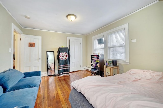 bedroom with ornamental molding and hardwood / wood-style floors