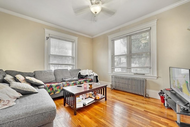 living room with ornamental molding, radiator heating unit, wood-type flooring, and a wealth of natural light