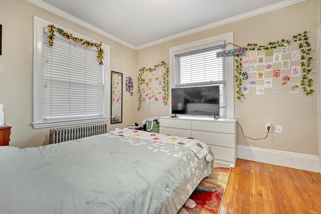 bedroom featuring hardwood / wood-style floors, crown molding, and radiator heating unit