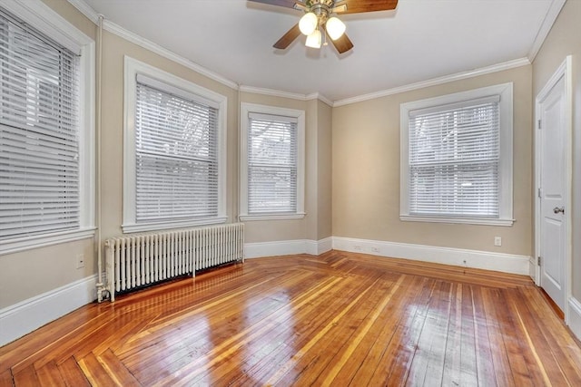 empty room featuring crown molding, ceiling fan, radiator, and light hardwood / wood-style floors