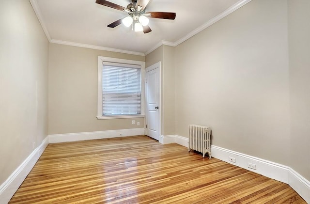 spare room featuring crown molding, ceiling fan, radiator heating unit, and light hardwood / wood-style floors