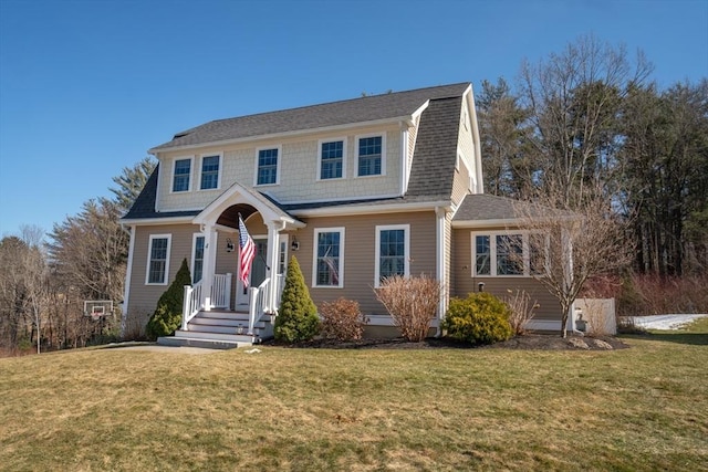 dutch colonial featuring a gambrel roof, a shingled roof, and a front yard