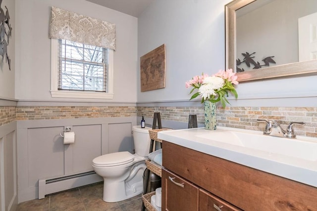 bathroom with vanity, toilet, and a baseboard heating unit