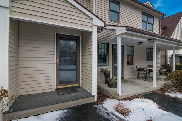 snow covered property entrance featuring a porch