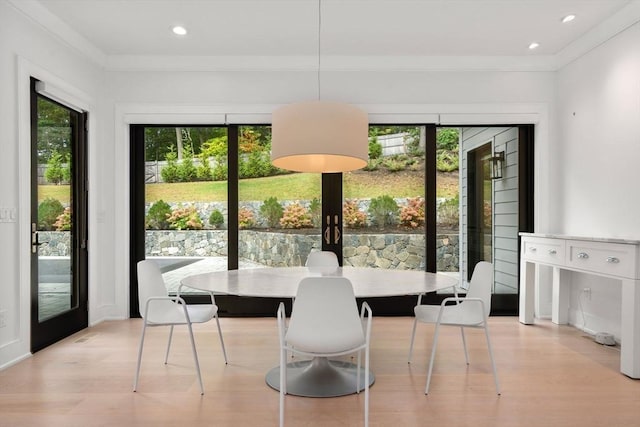 dining area with light wood finished floors, ornamental molding, and recessed lighting