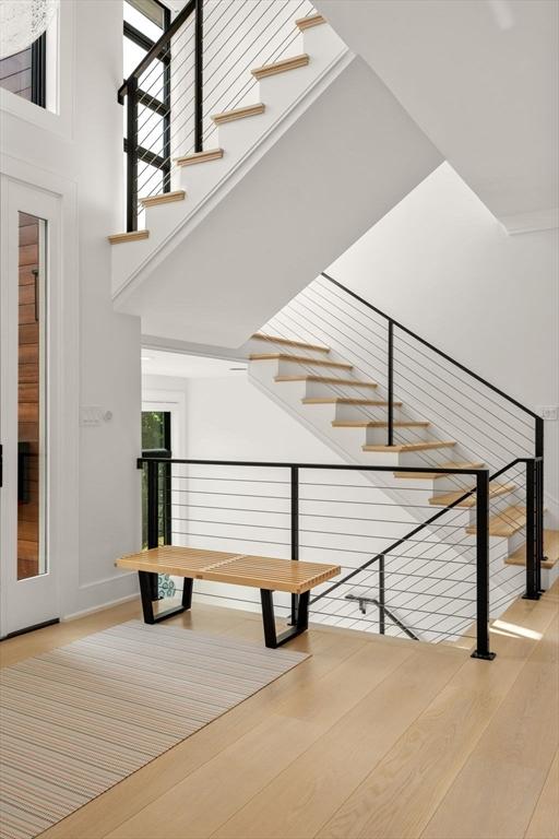 staircase with a towering ceiling and wood finished floors