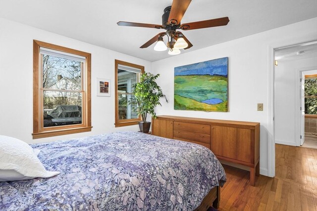 bedroom with hardwood / wood-style flooring, baseboards, and ceiling fan