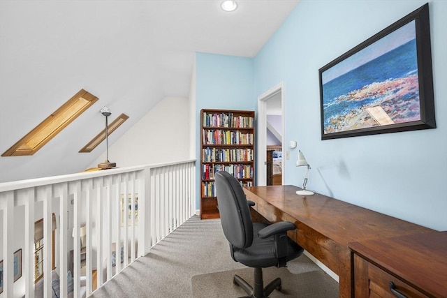 carpeted home office featuring vaulted ceiling