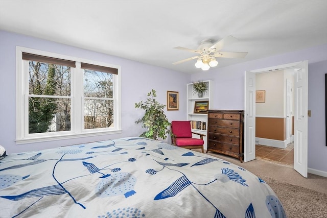 bedroom with ceiling fan, baseboards, and carpet