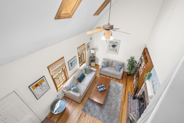 living area with high vaulted ceiling, a ceiling fan, baseboards, and wood finished floors