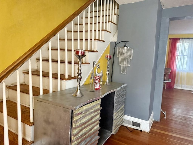 stairs featuring baseboards, visible vents, and wood finished floors