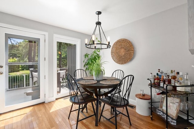 128 Parker St Unit 4C, Acton, MA 01720 - dining area featuring light wood-type flooring, a chandelier, and baseboards