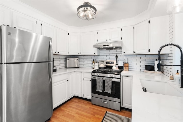 128 Parker St Unit 4C, Acton, MA 01720 - kitchen with stainless steel appliances, under cabinet range hood, a sink, and light countertops
