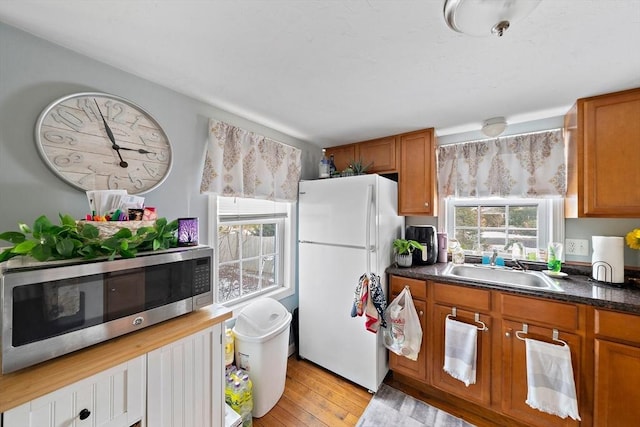 kitchen featuring white refrigerator, sink, and light hardwood / wood-style flooring