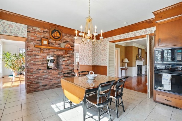 157 Washington St, Duxbury, MA 02332 - dining space with light tile patterned floors, a wainscoted wall, a chandelier, and a brick fireplace