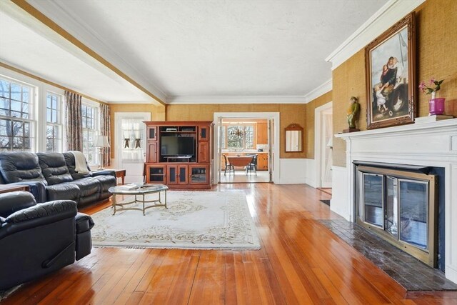 157 Washington St, Duxbury, MA 02332 - living area with ornamental molding, wood-type flooring, a wainscoted wall, and a glass covered fireplace