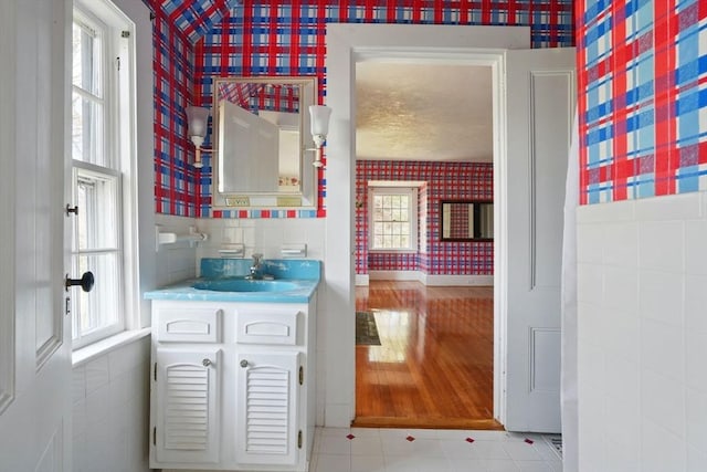 157 Washington St, Duxbury, MA 02332 - bathroom featuring tile walls, a healthy amount of sunlight, vanity, and wallpapered walls
