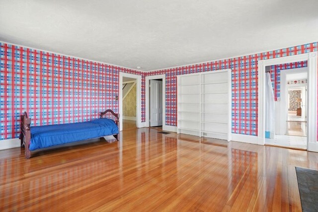 157 Washington St, Duxbury, MA 02332 - unfurnished bedroom with wallpapered walls, wood finished floors, baseboards, and visible vents