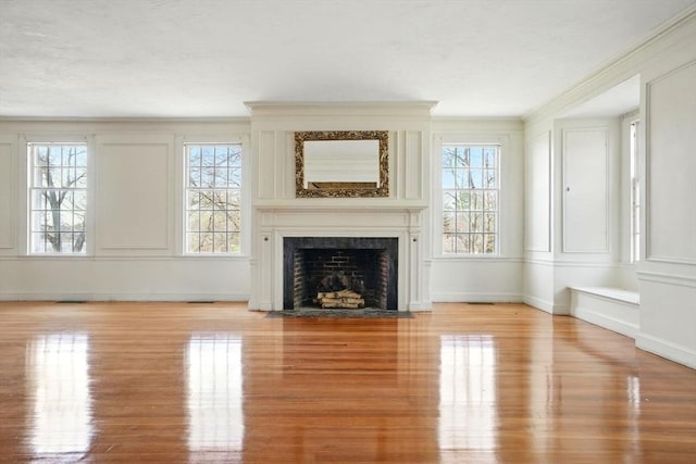 157 Washington St, Duxbury, MA 02332 - unfurnished living room featuring crown molding, a decorative wall, a fireplace with flush hearth, wood finished floors, and baseboards