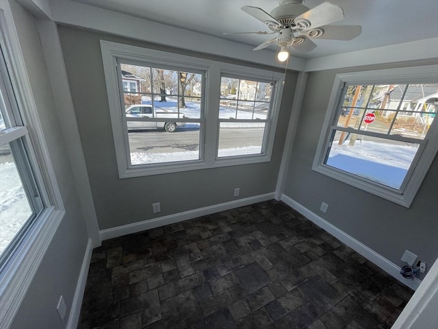 unfurnished dining area featuring a wealth of natural light and ceiling fan