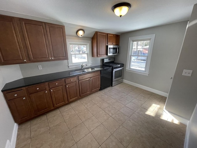 kitchen featuring sink, light tile patterned floors, a wealth of natural light, and appliances with stainless steel finishes