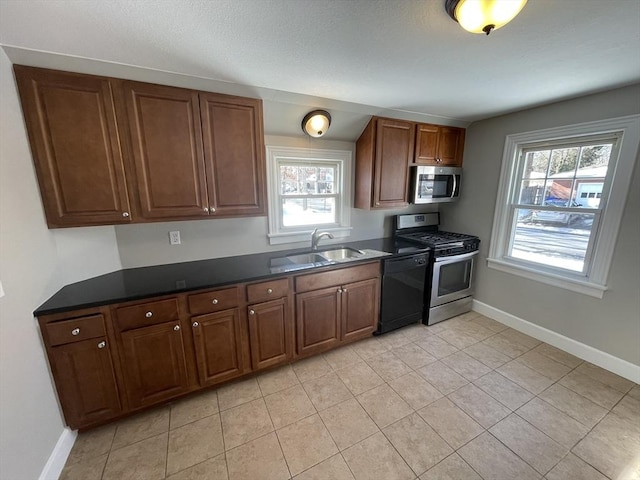 kitchen with light tile patterned flooring, appliances with stainless steel finishes, and sink