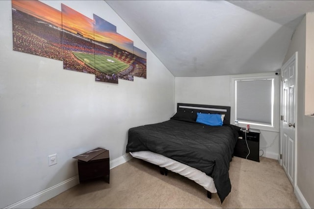 bedroom featuring lofted ceiling and light carpet