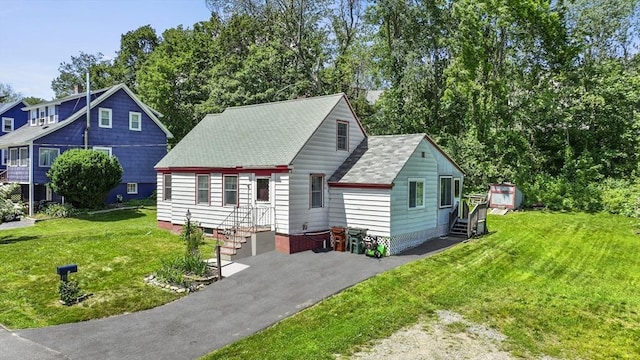 18 Stover Ct, Amesbury, MA 01913 - view of front of property featuring roof with shingles, a front yard, and view of wooded area