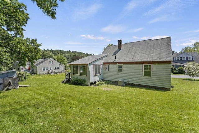 18 Stover Ct, Amesbury, MA 01913 - back of property with a lawn and a chimney