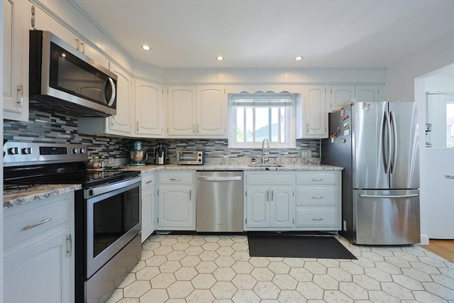 40 Atwood St, Revere, MA 02151 - kitchen featuring appliances with stainless steel finishes, light stone counters, white cabinets, and recessed lighting