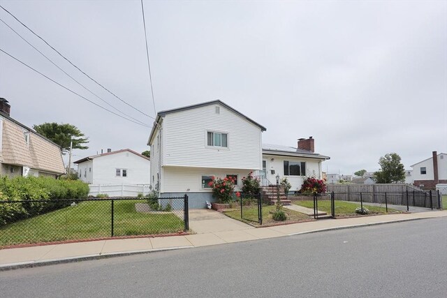 40 Atwood St, Revere, MA 02151 - view of front facade with a chimney, solar panels, and a fenced front yard