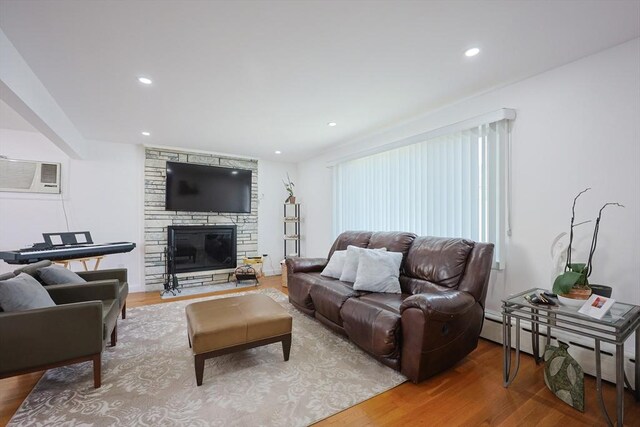 40 Atwood St, Revere, MA 02151 - living room with wood finished floors, an AC wall unit, a stone fireplace, a baseboard radiator, and recessed lighting