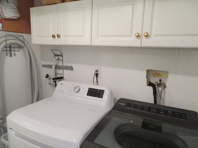 laundry room with cabinets and washing machine and clothes dryer