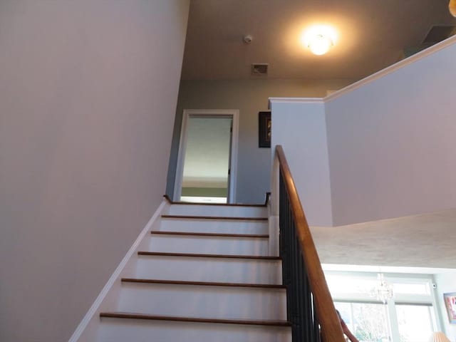 stairway with a notable chandelier