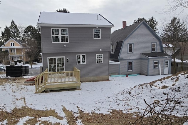 snow covered house with a deck