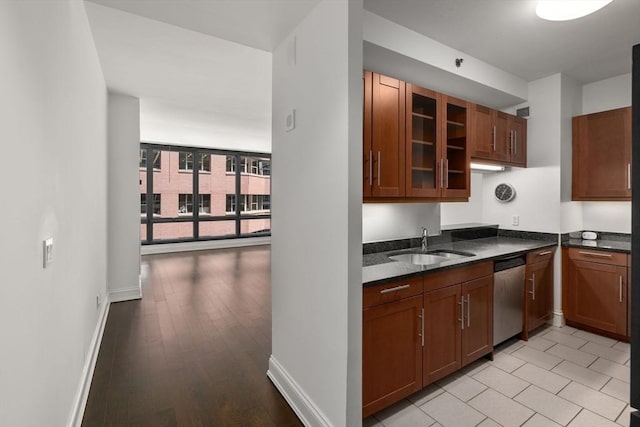 1 Charles St S Unit 604, Boston, MA 02116 - kitchen with dishwasher, a sink, glass insert cabinets, baseboards, and dark stone counters