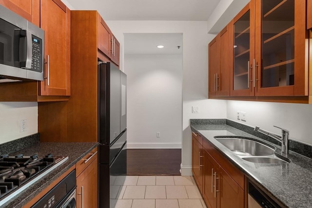 1 Charles St S Unit 604, Boston, MA 02116 - kitchen featuring appliances with stainless steel finishes, a sink, brown cabinets, glass insert cabinets, and light tile patterned flooring