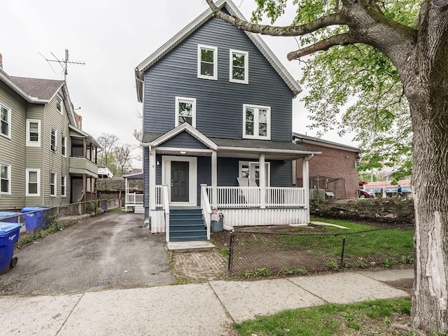 view of front facade with covered porch and a fenced front yard